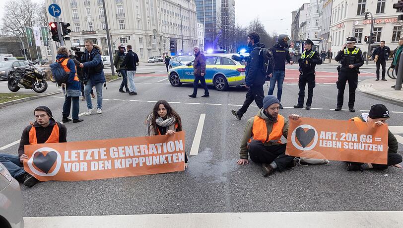 Aktivisten der Umweltgruppe "Letzte Generation" haben sich auf dem Hamburger Gorch-Fock-Wall und wollen damit auf Klimakrise aufmerksam machen.