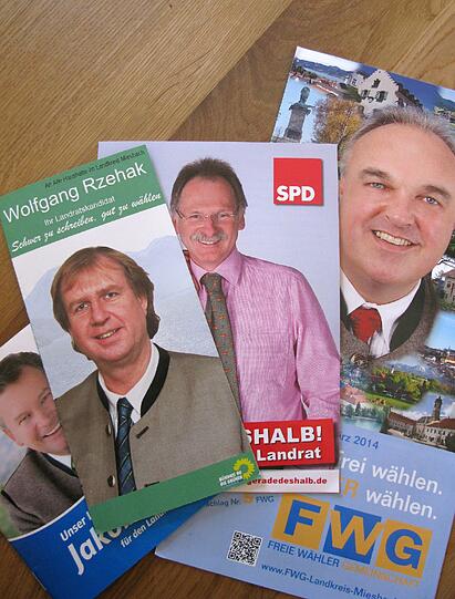 Werbeflyer von Landratskandidaten in Miesbach. Nach dem Verzicht des Miesbacher Affären-Landrats Jakob Kreidl gehen Bewerber von SPD, Grünen, Freien Wählern und FDP ins Rennen um die Nachfolge des CSU-Mannes.