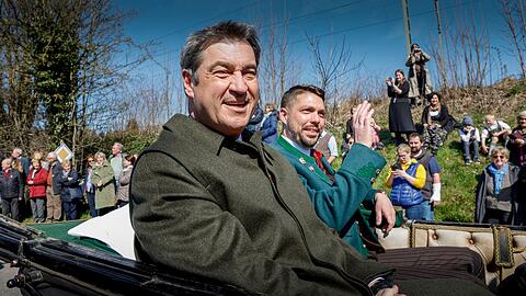 Bayerns Ministerpräsident Markus Söder (CSU, l) und der Traunsteiner Landrat Siegfried Walch (r) sitzen in einer Ehrenkutsche.