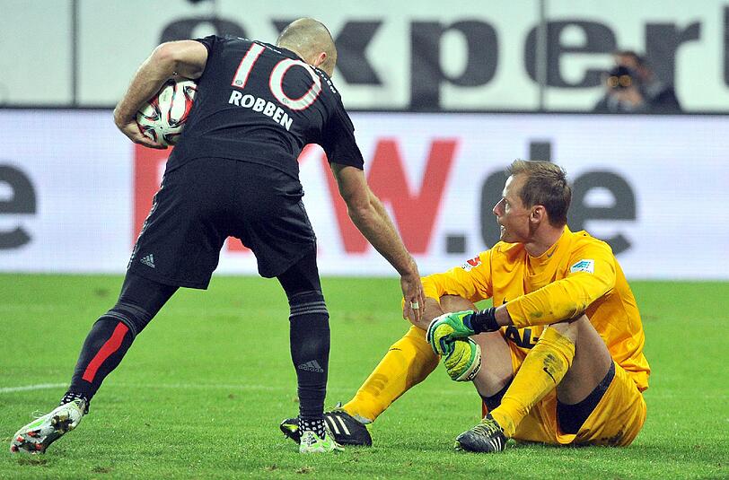 Münchens Arjen Robben (l) hilft Augsburgs Torwart Alexander Manninger nach einem Gegentor auf.