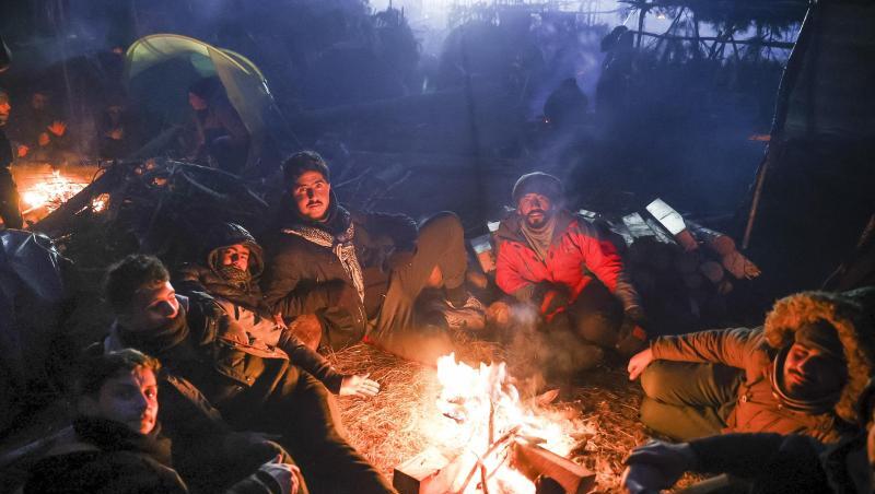 Migranten wärmen sich an einem Feuer an der belarussisch-polnischen Grenze auf.