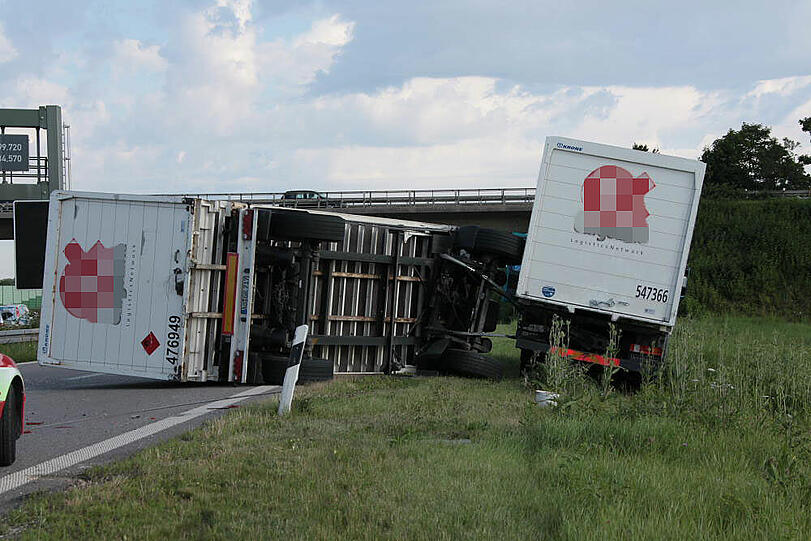 Vermutlich weil er zu schnell auf die Autobahn fährt, kommt ein Laster in der Kurve von der Fahrbahn ab und fährt in die Leitplanke. Sein Hänger kippt um.