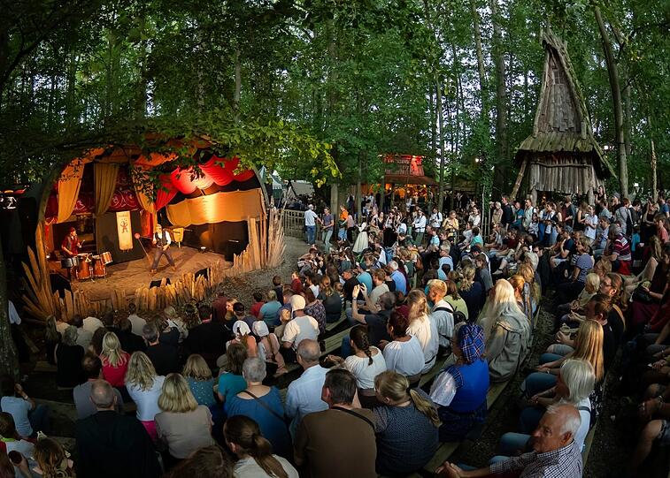 Gaukler musizieren und zeigen ihre Kunststücke auf der Waldbühne, eine der fünf Bühnen auf dem Kaltenberger Gelände.