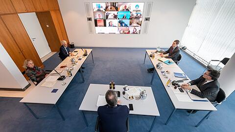 Staatsrätin Karolina Gernbauer (l), Ministerpräsident Markus Söder und Florian Herrmann (r, CSU), Leiter der Staatskanzlei und Staatsminister für Bundes- und Europaangelegenheiten und Medien sind physisch anwesend, die anderen Teilnehmen auf der Videoleinwand zugeschaltet.