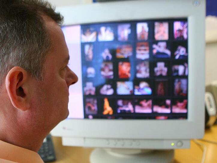 Ein Polizeifahnder sitzt vor einem Computerschirm