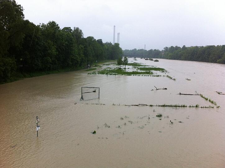 Land unter an der Isar. Nur das Tor vom Fußballrasen ragt heraus.