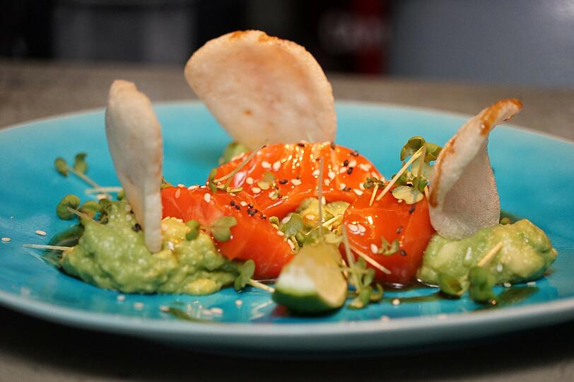1. Gang: Sashimi vom Lachs auf Avocadocreme mit Krabbenchip und Sesam.