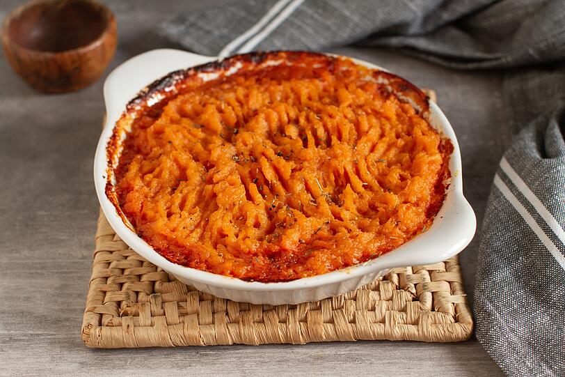 Gie&szlig;e die S&uuml;&szlig;kartoffeln ab und zerdr&uuml;cke Sie sie zu einem Mus. R&uuml;hren Sie 50 Milliliter Haferdrink, 100 Gramm Paprika-Frischk&auml;se, 80 Gramm geriebenen Parmesan, Salz und etwas Muskat ein. Geben Sie die Gem&uuml;se-Soja-Mischung in eine Auflaufform, verteilen Sie das S&uuml;&szlig;kartoffelmus dar&uuml;ber und backen Sie den Shepherd's Pie bei 220 Grad Ober- und Unterhitze etwa 15 Minuten, bis er goldbraun ist. Abschlie&szlig;end k&ouml;nnen Sie ihn mit frischer Petersilie garnieren.
