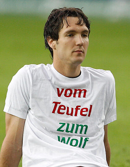 Kaiserslauterns Srdjan Lakic sitzt mit einem T-Shirt mit der Aufschrift "vom Teufel zum Wolf" auf dem Spielfeld. Lakic wechselt in der kommenden Saison zum VfL Wolfsburg.