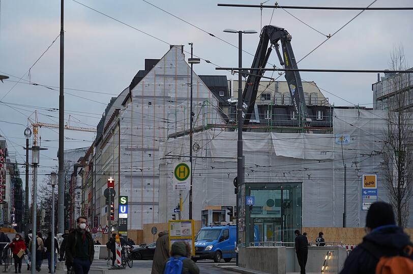 So schaut's am Eingang zur Schillerstraße aus: Hinter dem weiß verhängten Gerüst reißt eine Abrissbirne gerade das Eckgebäude nieder...