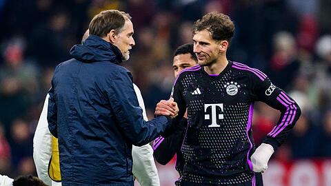 Münchens Trainer Thomas Tuchel (l) klatscht nach dem Spiel mit Münchens Leon Goretzka (r) ab.