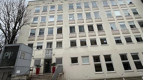 Das Pädagogische Institut von der Rückseite an der Marienstraße aus gesehen. Die Reliefs über dem Eingang zeigen Buchstaben, die Fenster sind mit hellen Steinen unterfangen.