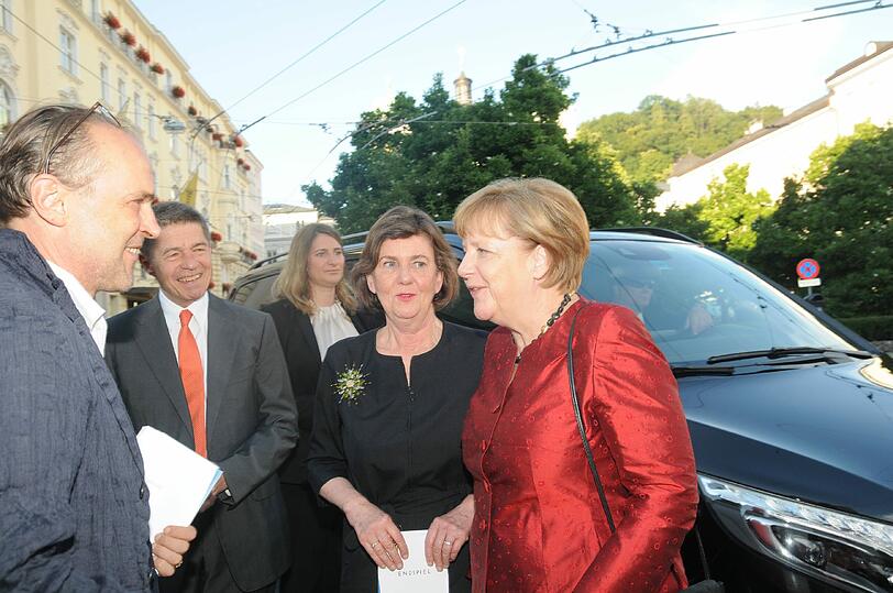 Festspielchef Sven-Eric Bechtolf (li.) und die Festspiel-Präsidentin Helga Rabl-Stadler (2. v. r.) begrüßen Angela Merkel zur Beckett-Premiere vor dem Salzburger Landestheater.