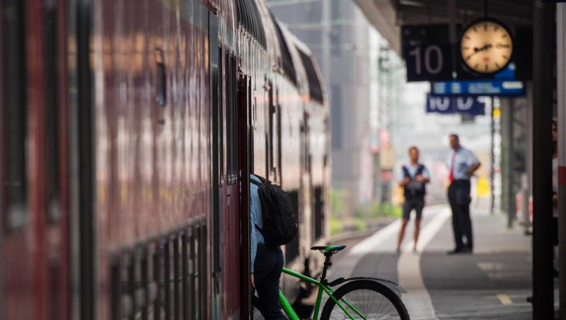 Ein Mann steigt mit seinem Fahrrad in einen Zug. Ein Mann steigt mit seinem Fahrrad in einen Zug.