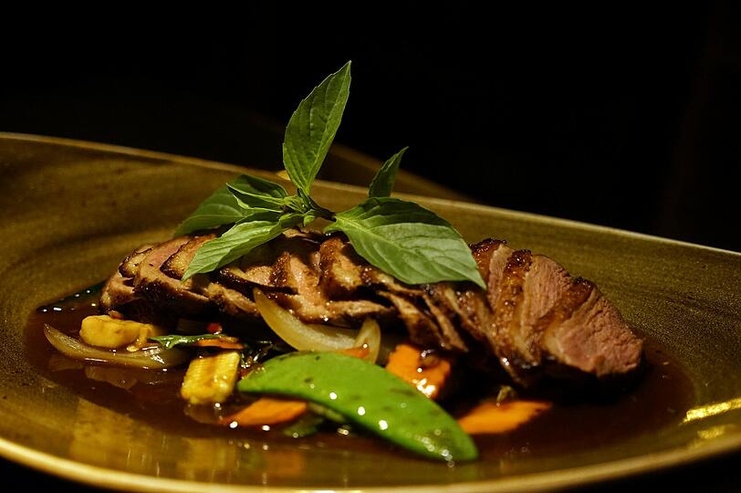 4. Gang: Saftiges Filet von der Barbarie-Ente, rosa gegrillt, auf Babymais, Karotten und Schoten, mit Basilikumsauce