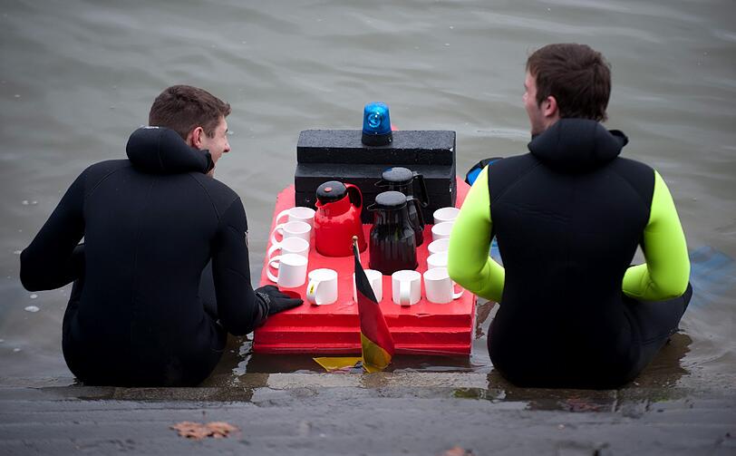 Die Teilnehmer sprangen von einem Feuerwehrboot aus in den Rhein, um mehrere hundert Meter flussabwaerts zu schwimmen.