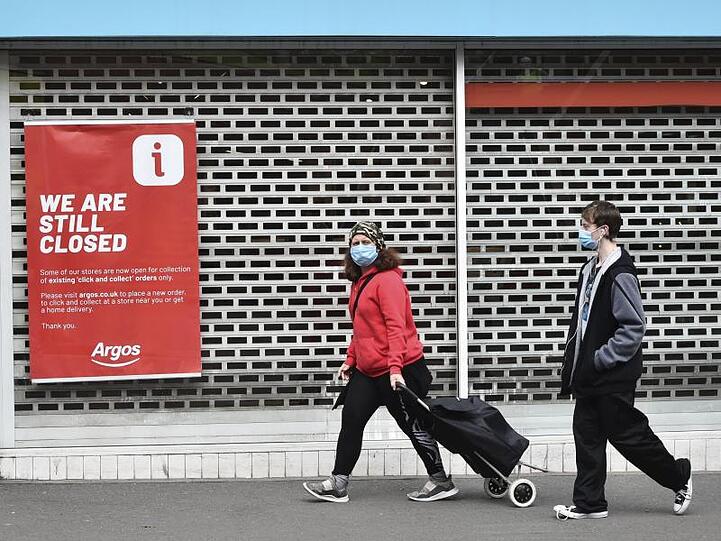 Menschen mit Mundschutz gehen Ende Juni an einem geschlossenen Laden im Stadtzentrum von Leicester vorbei. Großbritannien ist wegen der Corona-Krise in eine Rezession gerutscht.
