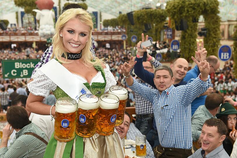 Wiesnplaymate Denise Cotte mit vier Maß in den Händen.