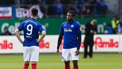 Franck Evina (r) steht auf dem Rasen. Foto: Frank Molter/dpa/Archivbild