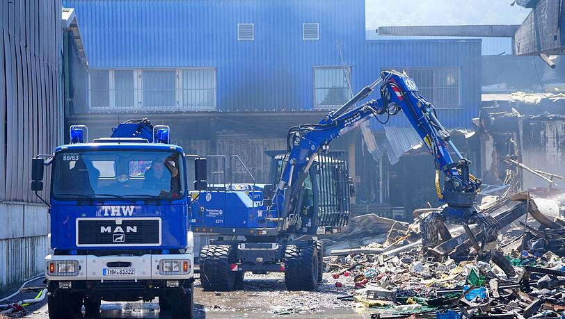 Einsatzkr&auml;fte des Technischen Hilfswerks (THW) beseitigen mit einem Bagger Schutt.