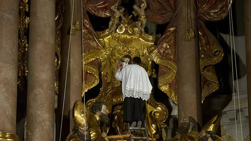 Der Mesner des Alten Peter in der Münchener Innenstadt nimmt der Petrus-Figur die Tiara vom Haupt. Der Mesner des Alten Peter in der Münchener Innenstadt nimmt der Petrus-Figur die Tiara vom Haupt.