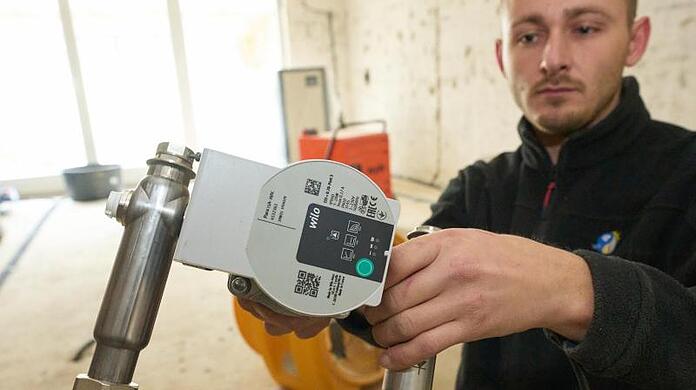 Ein Installateur baut in einem von der Flutkatastrophe betroffenen Haus eine Fußbodenheizung ein.