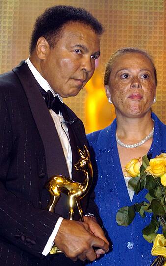Box-Legende Muhammad Ali hält am 27.11.2003 bei der 55. Bambi-Verleihung in Hamburg neben seiner Ehefrau Lonnie das goldene Rehkitz in den Händen.