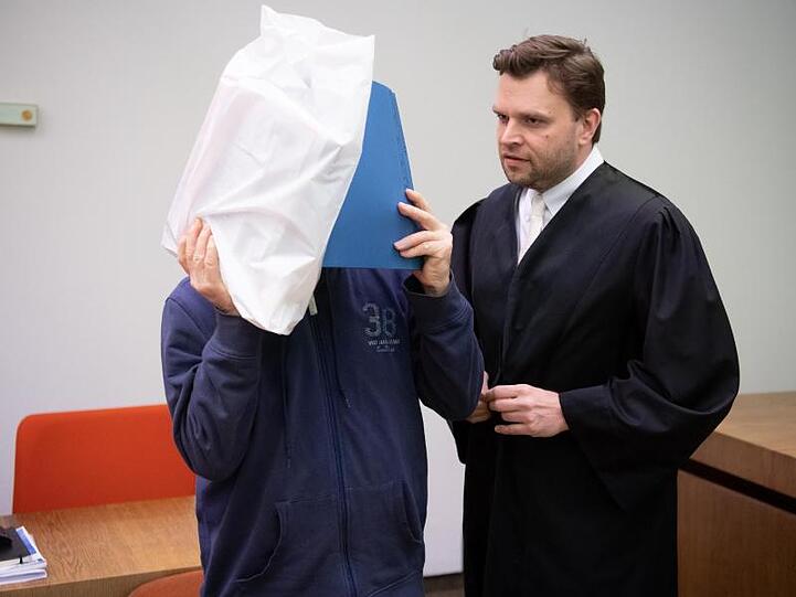 Der wegen sexuellen Missbrauchs Angeklagte (l) steht vor Prozessbeginn im Gericht zusammen mit seinem Anwalt im Sitzungssaal. Foto: Sven Hoppe
