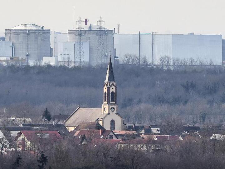 Der Kirchturm der katholischen Kirche St. Peter und Paul in deutschen Hartheim am Rhein ist vor dem Atomkraftwerk Fessenheim auf der französischen Seite der Grenze zu sehen.