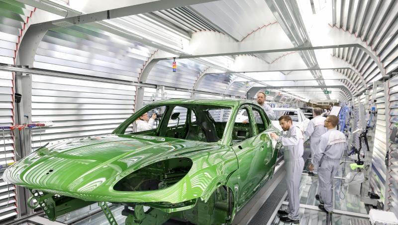 Ein Mitarbeiter prüft den Lack an einem Porsche Macan in der Lackiererei im Porsche-Werk Leipzig. Foto: Jan Woitas/Archiv Ein Mitarbeiter prüft den Lack an einem Porsche Macan in der Lackiererei im Porsche-Werk Leipzig. Foto: Jan Woitas/Archiv