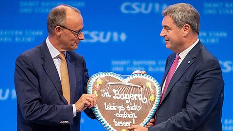 Die Unionsparteien geben sich seit geraumer Zeit betont geschlossen: Dieses Bild stammt vom CSU-Parteitag im September, bei dem der CDU-Vorsitzende Friedrich Merz (l.) von CSU-Chef Markus Söder ein Lebkuchenherz mit der Aufschrift "In Bayern lebt es sich einfach besser!" geschenkt bekam.
