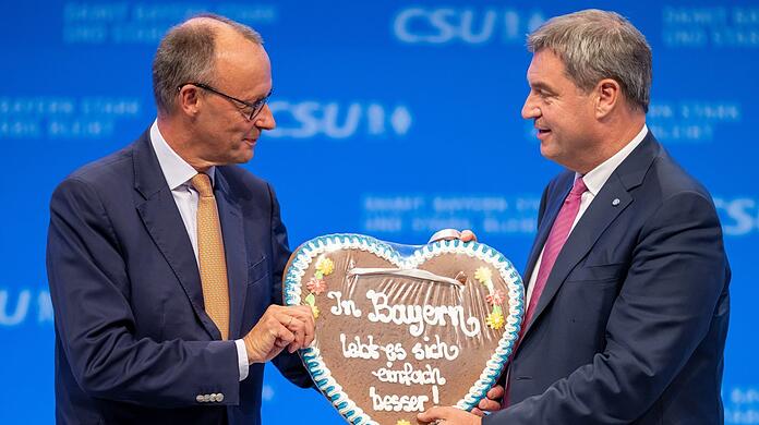Die Unionsparteien geben sich seit geraumer Zeit betont geschlossen: Dieses Bild stammt vom CSU-Parteitag im September, bei dem der CDU-Vorsitzende Friedrich Merz (l.) von CSU-Chef Markus Söder ein Lebkuchenherz mit der Aufschrift "In Bayern lebt es sich einfach besser!" geschenkt bekam.