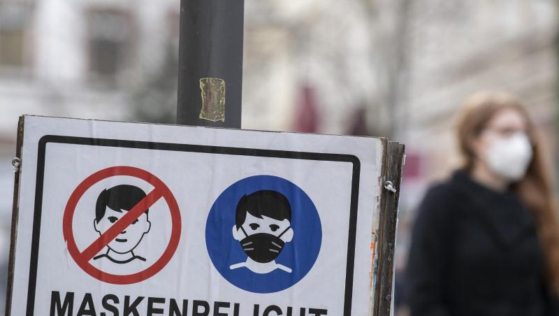 Plakate erinnern in einer fußgängerzone an die Einhaltung der Maskenpflicht.