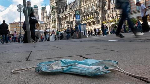Eine getragene Mundschutzmaske liegt in der Münchener Innenstadt auf dem Gehweg. Seit Mittwoch ist die Maskenpflicht in Teilen der Münchner Innenstadt aufgehoben.