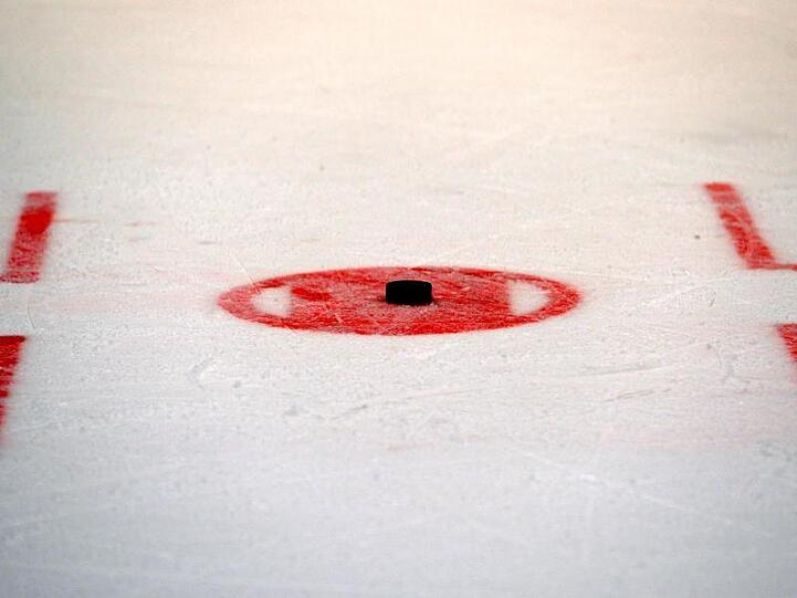Ein Puck liegt auf dem Eis zum Bully bereit. Foto: Thomas Eisenhuth/dpa-Zentralbild/dpa/Archivbild