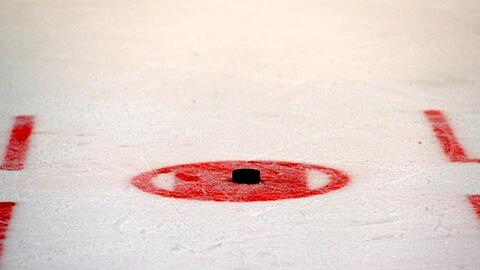 Ein Puck liegt auf dem Eis zum Bully bereit. Foto: Thomas Eisenhuth/dpa-Zentralbild/dpa/Archivbild