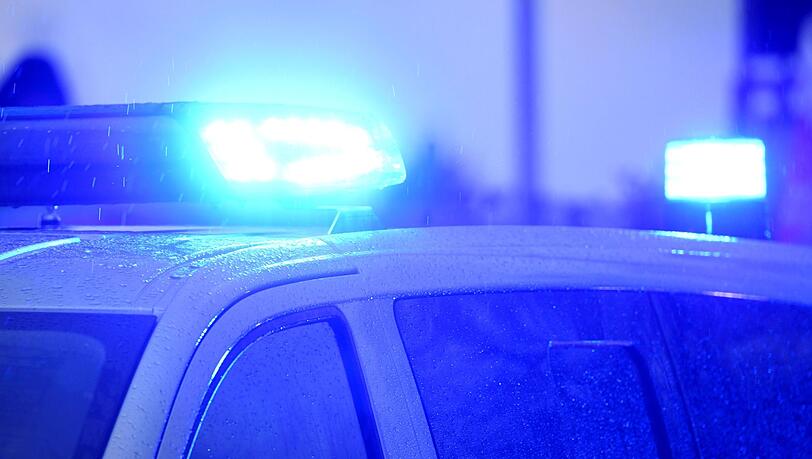 Blaulichter leuchten auf dem Dach eines Polizeifahrzeugs.