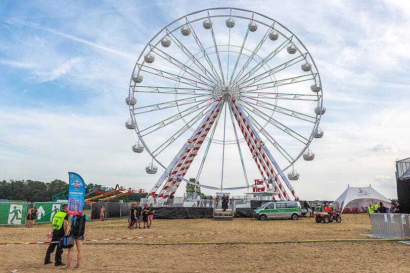 Einsatzkräfte der Polizei stehen an dem Riesenrad, auf dem sich der Unfall am Samstag ereignet hatte.
