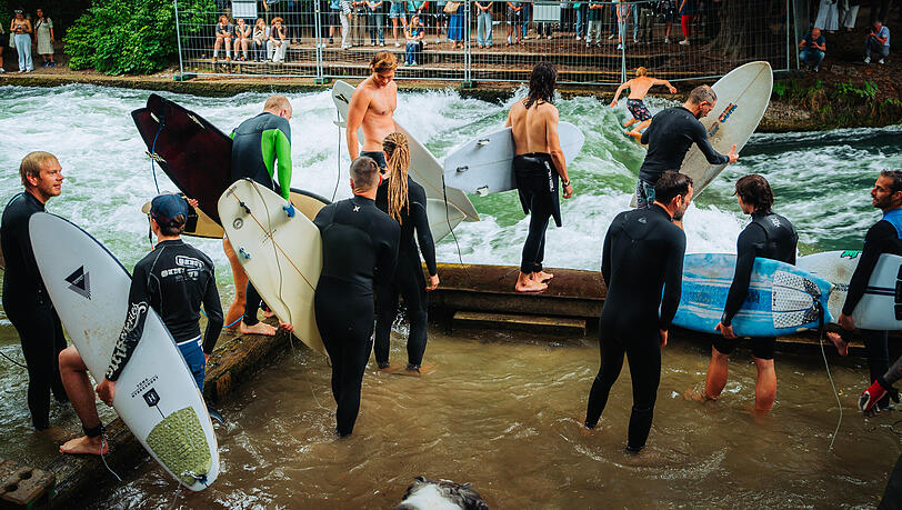 Die Surfer stehen am Bachufer Schlange, um endlich wieder ihre geliebte Eisbachwelle reiten zu können.