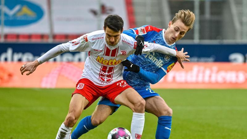 Sebastian Stolze von Regensburg und Joshua Mees von Kiel (l-r.) im Duell um den Ball.