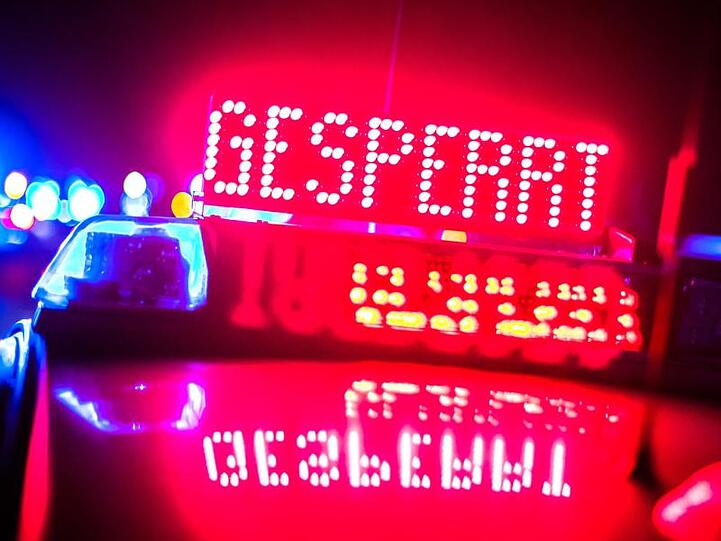 "Gesperrt" wird auf der Autobahn auf einem Polizeifahrzeug angezeigt.