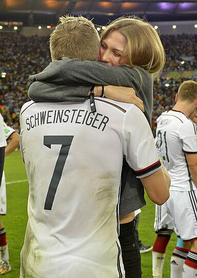 Bayern-Star und WM-Held Bastian Schweinsteiger hält Freundin Sara Brandner fest im Arm.