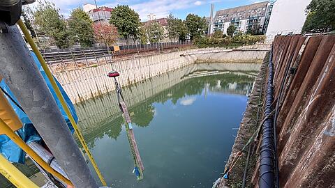 Zur Zeit sind keine Arbeiter in der Baugrube an der Alram- und Aberlestraße zu sehen. Doch sie haben schon viel gemacht. Von dem Ponton (im Bild unten Mitte) und von einem Boot aus haben sie alle Sicherungsanker (runde blaue Deckel in der linken Wand) oberhalb des Wasserspiegels überprüft. Sobald die Freigabe da ist, wird das restliche Wasser abgepumpt. Rund fünf Jahre stand es bis acht Meter hoch im Sendlinger Loch.