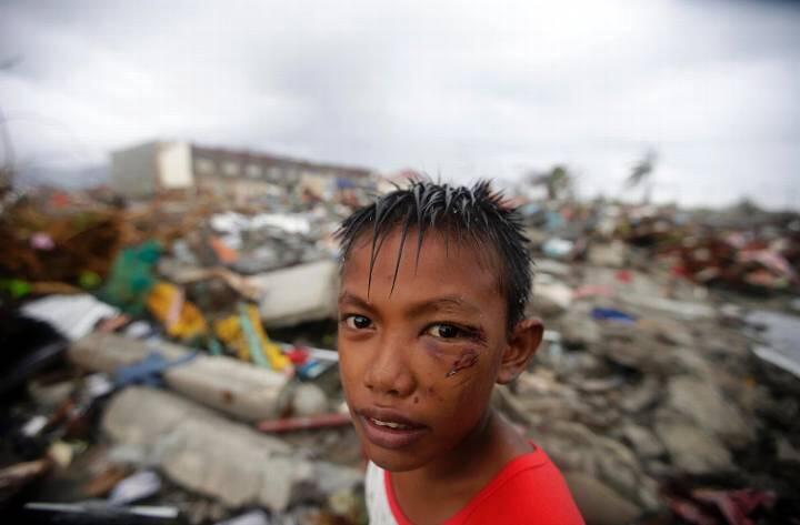 Ein junger Philippino steht zwischen eingestürzten Häusern in der Stadt Tacloban. Die Angst vor dem, was jetzt kommt ist ihm ins Gesicht geschrieben.