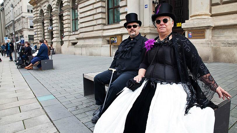 Ein Pärchen im Steam-Punk Stil ruht sich auf dem Wave-Gotik-Treffen auf einer Bank aus.