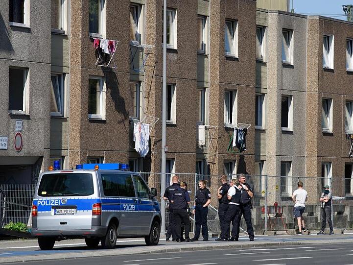 Einsatzkräfte der Polizei vor einem unter Quarantäne gestellten Wohngebäude.