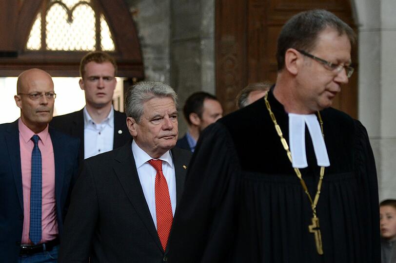 Gemeinsam mit seiner Lebensgefährtin Daniela Schadt (mitte) und dem sachsen-anhaltinischen Ministerpräsident Reiner Haseloff (CDU, links) betet Bundespräsident Joachim Gauck (rechts) in der Marktkirche von Halle. Die Bilder.