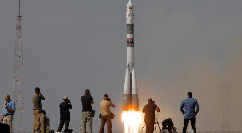 Die Sojus-FG Startrakete mit dem Raumfahrzeug Sojus startet zur Internationalen Weltraumstation von dem Kosmodrom Baikonur, im Vordergrund stehen Fotografen.