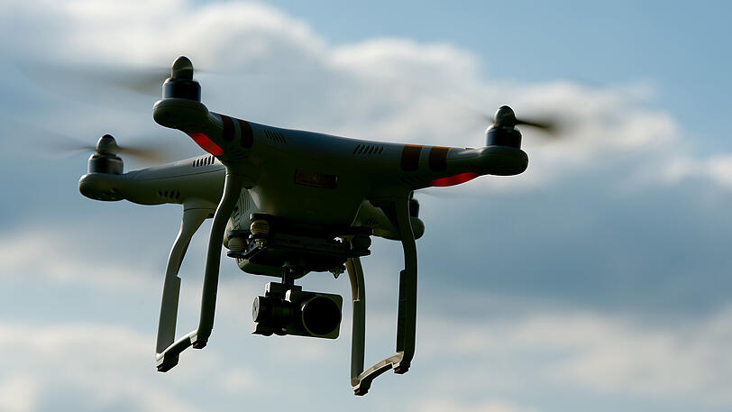 Eine ferngesteuerte Drohne (Quadrocopter) fliegt in der Nähe von Warngau (Bayern) über ein Feld.