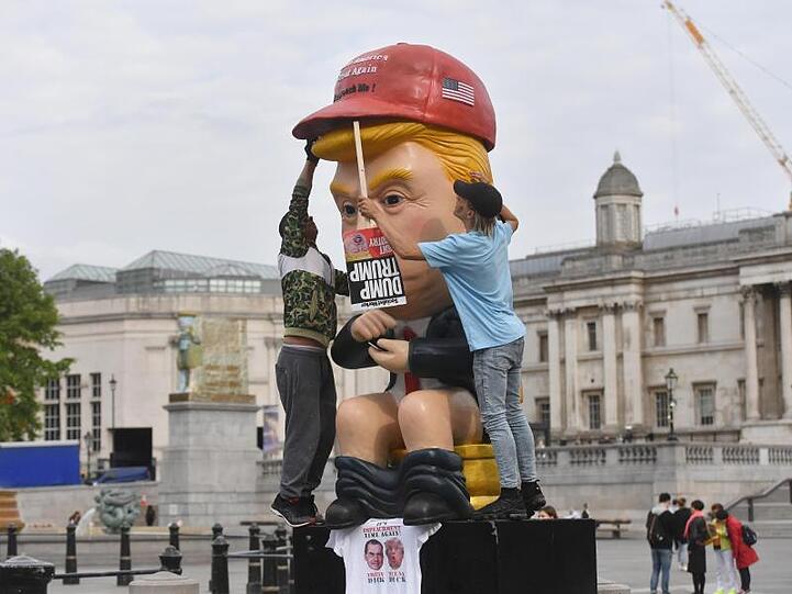 So sehen ihn manche Briten: Ein knapp 5 Meter großer sprechender Roboter, in der Anmutung von US-Präsident Trump sitzt am Trafalgar Square auf einer Goldtoilette.